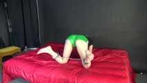 *** Sexy MIA wearing a green shiny nylon shorts and a black top ties and gagges herself with cuffs and a clothgag on a bed (Video)***