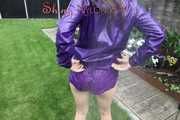 Watching sexy Aiyana wearing a sexy purple shiny nylon shorts and a purple shiny nylon rain jacket enjoying the garden shower (Pics)