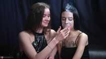 Two girls smoking from each others hands