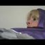 Pia bound and gagged on bed in a shiny purple/silver PVC sauna suit (Video)