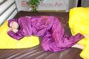 Lucy wearing a supersexy purple rain suit with hood while preparing her bed (Pics)