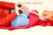 Jill tied and gagged on a white sofa wearing a lightblue nylon shorts and a red/darkblue rain jacket (Pics)
