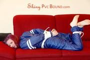 Mara tied and gagged on a sofa wearing a shiny blue PVC sauna suit (Pics)