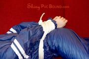 Mara tied and gagged on a sofa wearing a shiny blue PVC sauna suit (Pics)