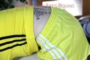 Mara tied and gagged bending over an sofa wearing a yellow shiny nylon shorta (Pics)