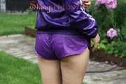 Watching sexy Aiyana wearing a sexy purple shiny nylon shorts and a purple shiny nylon rain jacket enjoying the garden shower (Pics)