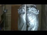a video with Nicole tied and gagged in a shiny silver PVC sauna suit