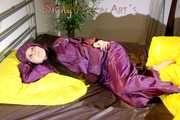 Lucy wearing a supersexy purple rain suit with hood while preparing her bed (Pics)