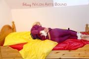 Pia in a shiny purple rainsuit tied and gagged in bed (Pics)