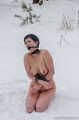 Naked barefoot brunette chained in the snow