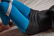 Tied arms and suspended legs in blue leggings