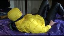 Pia tied, gagged and hooded on bed with cuffs and a gag wearing a hot darkblue rain pants and a big yellow down jacket (Video)