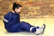 Jill tied and gagged in an old cellar on the floor wearing a shiny blue PVC sauna suit (Pics)
