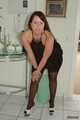 Chubby Benita posing in a black dress, stockings and heels