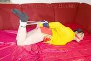 ***LUCIE*** wearing red/yellow shiny nylon shorts and a yellow shiny nylon rain jacket being bound on a sofa with ropes and a ball gag (Pics)