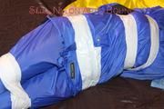 Lucy taped, hooded and gagged on bed wearing sexy blue rainwear (Pics)