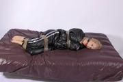 Sophie tied and gagged by using tape on bed wearing a shiny black sauna suit (PICS)