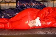Mara tied and gagged on a princess bed in an old cellar wearing a sexy red sauna suit (Pics)