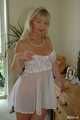 Busty blonde Marlen posing in a white negligee in the bedroom