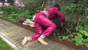 Watching Aiyana wearing supersexy pink shiny nylon rainwear while planting flowers in the garden (Video)