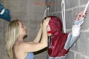 Nicole tied and gagged by Sophie in an red/silver PVC rainsuit in the cellar