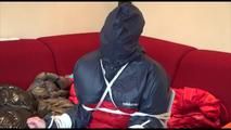 Jill tied, gagged and double hooded on a chair wearing shiny nylon shorts and two shiny nylon rain jackets (Video)