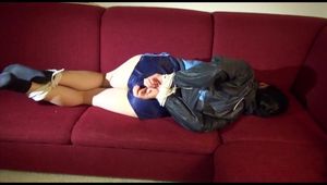 Lucy tied and gagged on a red sofa wearing a supersexy blue shiny nylon shorts and a blue rain jacket (Video)