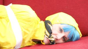 Mara tied, gagged and hooded with tape on a red sofa wearing shiny yellow rainwear (Pics)