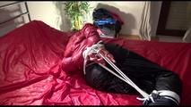 Lucy tied and gagged on bed wearing a sexy black shiny nylon pants and a red down jacket (Video)