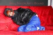 Sonja wearing a sexy blue shiny nylon raver pants and a black down jacket being tied and gagged with ropes on a sofa (Pics)