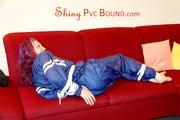 Mara tied and gagged on a sofa wearing a shiny blue PVC sauna suit (Pics)