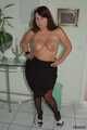 Chubby Benita posing in a black dress, stockings and heels