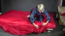 Watching Sonja wearing supersexy red/blue shiny nylon rainwear preparing her bed with shiny nylon cloth (Video)