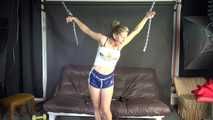 Watching sexy Sandra wearing an darkblue shiny nylon shorts and a white adidas top being tied and gagged overhead with ropes, chaines and a ballgag (Video)
