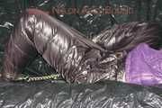 Sandra tied and gagged on a sofa with cuffs and a pillory wearing hot purple down jacket and black down pants (Pics)