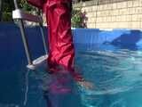 Watch Sandra watering the garden and wetting her shiny nylon oldschool Rainsuit in the Pool