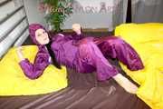 Lucy wearing a supersexy purple rain suit with hood while preparing her bed (Pics)