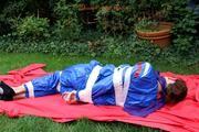 Nicole in an blue sauna suit tied and gagged in the garden (Pics)
