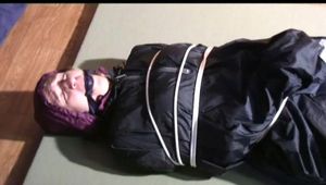 03:30 Min. video with Katharina tied and gagged in two layers of shiny nylon rainwear