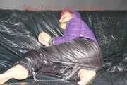 Sandra tied and gagged on a sofa with cuffs and a pillory wearing hot purple down jacket and black down pants (Pics)