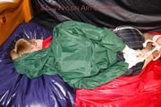 Samantha tied and gagged in bed wearing a black shiny nylon shorts and a green rainjacket (Pics)