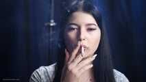 Brunette with mysterious look smoking all white cigarette