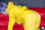 MARA wearing a sexy yellow shiny nylon rain suit lolling and posing on a bed (Pics)