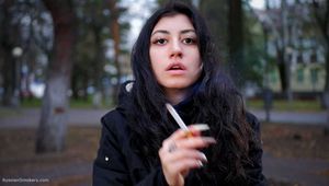 Raven-haired smoker takes a drag on a cork cigarette of her favorite brand