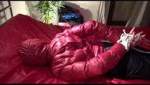 Lucy tied and gagged on bed wearing a sexy black shiny nylon pants and a red down jacket (Video)