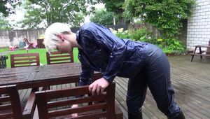 Watching sexy Courtney feeling comfortable in her dark blue  shiny nylon rainwear cleaning the table outside (Video)