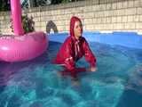 Watch Sandra watering the garden and wetting her shiny nylon oldschool Rainsuit in the Pool