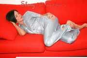 ENNI putting on a very sexy grey shiny nylon adidas rain catsuit and lolling and posing on a sofa (Pics)