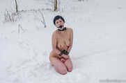 Naked barefoot brunette chained in the snow