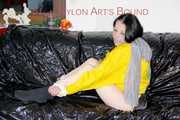 LUCY tied and gagged with ropes and a ballgag on a sofa wearing a sexy black/yellow shiny nylon shorts and a yellow rain jacket (Pics)